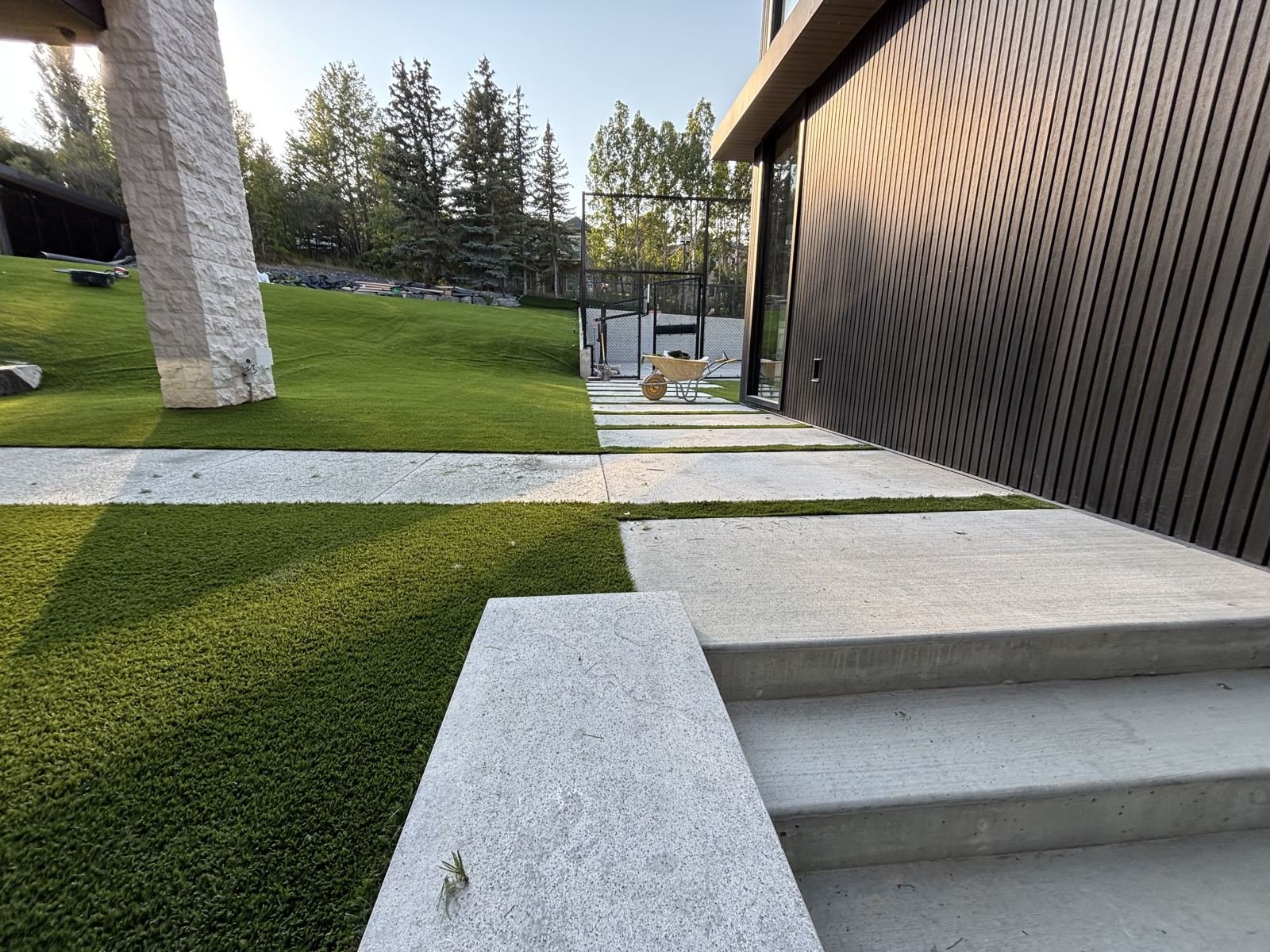 Artificial turf lawn with tree shade in backyard